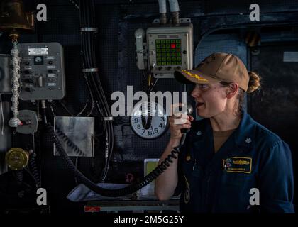 GOLFO ARABICO (16 marzo 2022) CMdR. Meghan Bodnar, ufficiale comandante, si rivolge all'equipaggio su un sistema intercom durante una cerimonia di premiazione del Guerriero della settimana a bordo del cacciatorpediniere missilistico guidato USS Gridley (DDG 101) nel Golfo Arabico, marzo 16. Gridley è schierato nell'area delle operazioni della flotta degli Stati Uniti 5th a sostegno delle operazioni navali per assicurare la stabilità e la sicurezza marittima nella regione centrale, collegando il Mediterraneo e il Pacifico attraverso l'Oceano Indiano occidentale e tre punti di arresto strategici. Foto Stock