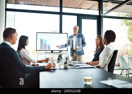 Fornendo loro i dati grezzi. un uomo d'affari che fa una presentazione in una sala riunioni. Foto Stock