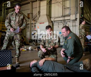 Da sinistra, Air Force Reserviser, 1st Lt. Mitchell Sartoski, E 1st Lt. Joseph Bowser, entrambi assegnati al 911th Aeromedical evacuation Squadron, 911th Airlift Wing fornire feedback a Pennsylvania Air National Guardsman, Master Sgt. Erik Larson dopo aver dimostrato la sua capacità di eseguire tecniche salvavita durante una valutazione del corso di tattica Combat Casualty Care il 16 marzo 2022. I 911th Airmen stanno diventando istruttori certificati TCCC attraverso le loro valutazioni. Foto Stock