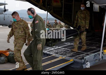 I militari assegnati al 86th° Squadrone di evacuazione per uso medico, al 86th° Gruppo medico e al 96th° Squadrone Airlift trasportano un paziente statunitense su un autobus medico dopo l'atterraggio alla base aerea di Ramstein, Germania, 16 marzo 2022. Gli aerei a servizio attivo e di riserva hanno sollevato otto pazienti statunitensi dalla Polonia e li hanno trasportati al Landstuhl Regional Medical Center, in Germania, per il trattamento. Lo scorso anno, i 86th equipaggi medici e aerei di AW hanno condotto 144 missioni di evacuazione per via biomedica che hanno trasportato e trattato 205 pazienti. I team hanno recentemente volato su una riserva dell'aeronautica C-130H Hercules schierata a Ramstein dagli anni '9 Foto Stock