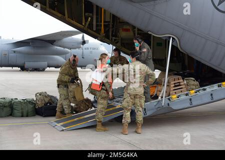 I militari assegnati al 86th° Squadrone di evacuazione per uso medico, al 86th° Gruppo medico e al 96th° Squadrone per uso aereo si preparano a trasferire i pazienti statunitensi su un autobus medico in attesa dopo l'atterraggio alla base aerea di Ramstein, Germania, 16 marzo 2022. L'equipaggio di Total Force Airmen ha sollevato otto pazienti attraverso un US Air Force Reserve C-130H che viene dispiegata a Ramstein AB dal Minnesota per supportare missioni tattiche di sollevamento aereo, tra cui evacuazioni di medicina aeronautica. Le squadre di evacuazione Aeromedica di Ramstein forniscono assistenza medica critica agli Stati Uniti Comando europeo e Stati Uniti Africa forze di comando operanti in tutta Europa e Afri Foto Stock