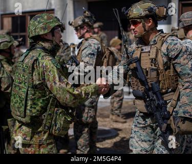 STATI UNITI Marines con la squadra di atterraggio del battaglione 1/5, 31st unità di spedizione marina e soldati giapponesi con il 1st Reggimento di distribuzione rapida anfibio (1ARDR) conducono il coordinamento integrato durante l'addestramento delle operazioni militari in terreno urbanizzato (MOUT) al centro di addestramento delle armi combinato Camp Fuji, Giappone, 16 marzo 2022. La formazione MOUT fornisce l'organizzazione, la pianificazione e le conoscenze necessarie per avere successo quando si eseguono operazioni in un ambiente urbano. Esercizio di difesa marittima la Brigata di rapida implementazione anfibia è un esercizio bilaterale volto ad aumentare l'interoperabilità e a rafforzarla Foto Stock