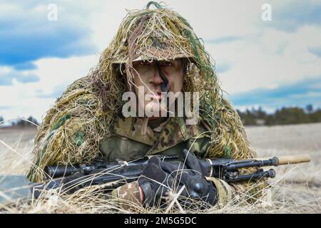 Lo staff Sgt. Aaron Lee, 341 Missile Security Operations Squadron, Malmstrom Air Force base, Montana, dimostra un'elevata crescita durante il corso Nuclear Advanced Designated Marksman 16 marzo 2022 a Camp Guernsey, Wyoming. I cecchini hanno diversi tipi di strisci che li aiutano a rimanere nascosti in qualsiasi ambiente. Foto Stock