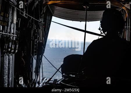 Personale dell'aeronautica Sgt. Jacob Thomas, un maestro di carico assegnato all'Ala 103rd Airlift, si prepara per un airdrop durante una missione di addestramento a bordo di un aereo C-130H, 16 marzo 2022, East Granby, Conn. I Loadmaster sono responsabili del corretto caricamento e fissaggio del carico per le gocce d'aria. Foto Stock