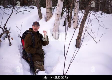 STATI UNITI Samuel Ley, un istruttore della Arctic Survival School, insegna agli studenti come accendiarsi per un'imbarcazione antincendio il 16 marzo 2022, sulla base dell'aeronautica di Eielson, Alaska. Agli studenti è stato insegnato come fare un fuoco per rimanere caldi e generare acqua mentre in una situazione di sopravvivenza artica. Foto Stock