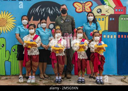 STATI UNITI John Gallemore, 8th Comandante dell'Ala combattente, si trova con gli studenti thailandesi nel distretto di MuangNakhonRatchasima, durante una cerimonia di donazione alla Scuola di Banchaimong Kope Tiger 2022 presso la base aerea thailandese Korat Royal, Thailandia, 16 marzo 2022. Dall’avvio di Cope Tiger nel 1994, i partecipanti all’esercitazione hanno continuato la tradizione delle donazioni a scopo di beneficenza alle scuole locali. Foto Stock