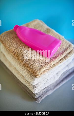 Biancheria fresca. una bottiglia di detergente sopra una pila di asciugamani piegati. Foto Stock