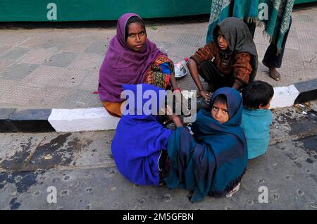 Una famiglia senza tetto che si sta riscaldando per le strade di Kolkata, India. Foto Stock