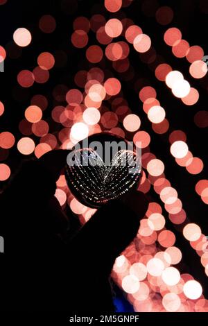 Luci fata a forma di cuore in una sfera con lente di vetro Foto Stock