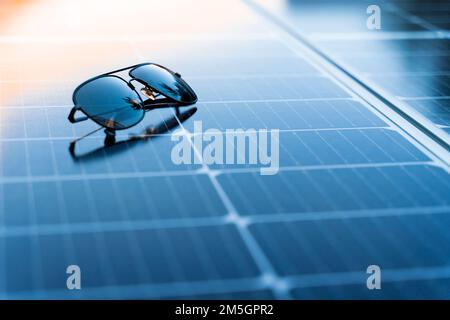 Occhiali da sole su un pannello solare con spazio copia Foto Stock