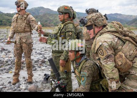 STATI UNITI Esercito Pacifico fuoco indiretto con il Battaglione 2nd, 27th reggimento fanteria, 3rd squadra di combattimento Brigata Fanteria, 25th divisione Fanteria, insieme ai soldati dell'esercito filippino con il Battaglione Fanteria 92nd, 1st squadra di combattimento Brigata, 2nd divisione Fanteria, Osservare l'area d'impatto della Malta per garantire che il giro abbia raggiunto il suo obiettivo durante un esercizio di addestramento combinato della Malta incentrato sulla tecnica di posa diretta durante il Salaknib 2022 a Fort Magsaysay, Nueva, Ecija, Filippine, marzo 17; 2022. Salaknib è un esercito filippino-guidato annuale, Stati Uniti L'Esercito Pacifico ha sponsorizzato l'esercizio bilaterale des Foto Stock