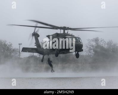 STATI UNITI I soldati dell'esercito, assegnati al 1st° Gruppo delle forze speciali (aereo) e ai soldati dell'esercito tailandese reale, salgono da un elicottero UH-60 Blackhawk come parte dell'addestramento helo-cast durante l'Hanuman Guardian 2022 a Loppuri, Regno di Thailandia, il 18 marzo 2022. HG 22 fornisce una sede sia per gli Stati Uniti che per l'RTA per promuovere l'interoperabilità e aumentare la capacità dei partner nella pianificazione e nell'esecuzione di complesse e realistiche forze multinazionali e operazioni combinate di task force. Foto Stock