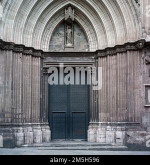 Dettaglio architettonico della porta laterale e della facciata della Cattedrale Gotica di Barcellona. Archi appuntiti e antica porta di ferro. Foto Stock