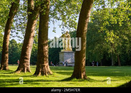 Maincy, Francia - 21 maggio 2022: Una vista da un vicolo giardino fiancheggiato da alberi di sicomoro di una scultura a foglia d'oro che rappresenta una copia di un ellenistico Foto Stock