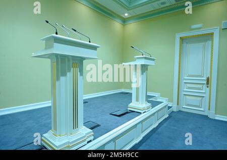 Due conferenze e due microfoni si sono posti sul palco nella sala del briefing stampa Foto Stock