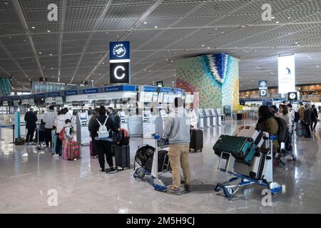 19 dicembre 2022, Narita, Giappone: I viaggiatori della stagione delle vacanze con i loro bagagli aspettano in fila per il check-in con le compagnie aeree affiliate all'alleanza SkyTeam all'aeroporto internazionale Narita. Il Giappone ha recentemente riaperto al turismo dopo oltre due anni di divieti di viaggio a causa della pandemia COVID-19. Lo Yen si è notevolmente deprezzato nei confronti del dollaro USA, creando turbolenze economiche per il commercio internazionale e l'economia giapponese. Anche il Giappone sta ora vivendo un conteggio giornaliero di oltre 100.000 nuovi casi di COVID-19 al giorno, mentre Tokyo rappresenta circa un quinto di questi casi causati dal virus SARS-COV-2. (Credito im Foto Stock