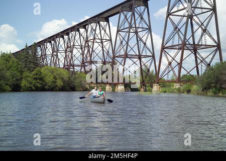 Sheyenne River Valley Scenic Byway - Paddling il fiume Sheyenne sotto il Viadotto Valley City. Una coppia può ammirare il paesaggio verde smeraldo mentre pagaia lungo le acque scintillanti del fiume Sheyenne sotto il viadotto di Valley City. Ubicazione: Valley City, Dakota del Nord (46,939° N 97,995° W) Foto Stock