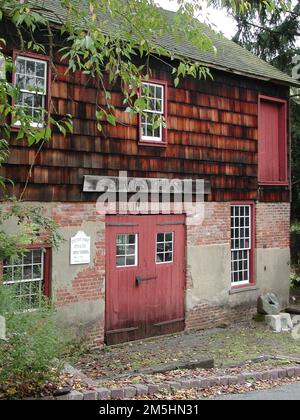 Millstone Valley Scenic Byway - Old Millstone Forge. Le scandole di legno fiancheggiano il muro del piano superiore, mentre un primo piano in cemento e grigio fanno un interessante contrasto con l'Old Millstone Forge, definita come il negozio di fabbro più longevo in America. Location: Italy Foto Stock