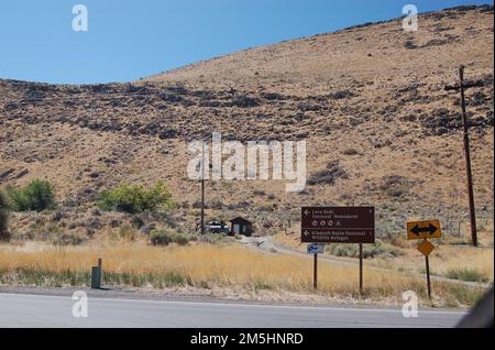 Volcanic Legacy Scenic Byway - seguendo la Byway da Tulelake. Una cresta fatta di un antico flusso lavico sorge dietro una serie di cartelli che dirigono i viaggiatori sulla Volcanic Legacy Scenic Byway fino al Monumento Nazionale di Lava Bed e ai Klamath Basin National Wildlife Refuges (vale a dire, il suo centro visitatori). Il posto include anche un cartello stradale di America's Byways. Località: Tulelake, California (41,953° N 121,566° W) Foto Stock