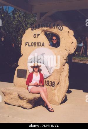 A1A Scenic e Historic Coastal Byway - riposo a Marineland. Due turisti si posano per una foto-op all'ingresso di Marineland. Località: Florida (29,668° N 81,213° W) Foto Stock