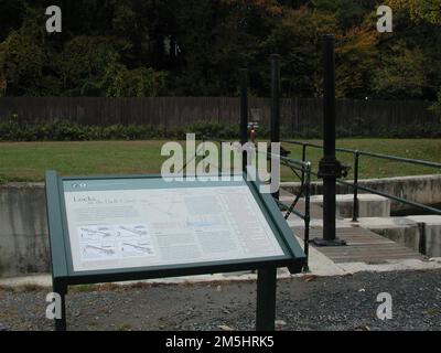 Millstone Valley Scenic Byway - la storia del canale D&R. Un prato verde si estende sotto gli alberi ombrosi dietro un cartello interpretativo che racconta la storia del Delaware e del canale Raritan. Location: Italy Foto Stock