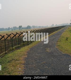 13.11.2022 . Radhikapur, Bengala Occidentale, India. Strada asfaltata nera accanto al confine internazionale tra India e Bangladesh paese. Foto Stock