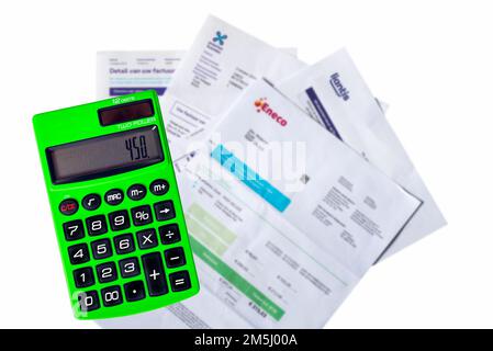 Calcolatrice tascabile verde e fatture/fatture di Eneco, fornitore di gas naturale ed elettricità, Proximus e Liantis su sfondo bianco Foto Stock