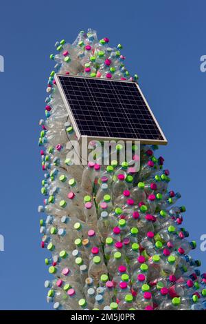 Albero di Natale ecologico realizzato con bottiglie di plastica e luci di Natale a energia solare: Una tradizione di vacanza sostenibile Foto Stock