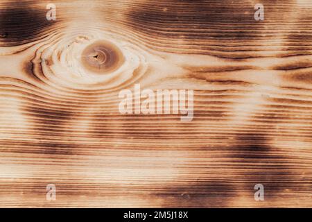 Asse di legno bruciato con un nodo, texture foto di sfondo primo piano Foto Stock