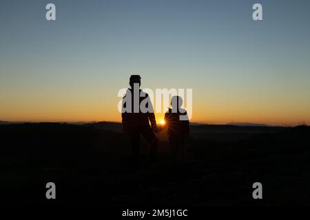 Madre e figlio si sono insilati al tramonto mentre camminavano Foto Stock