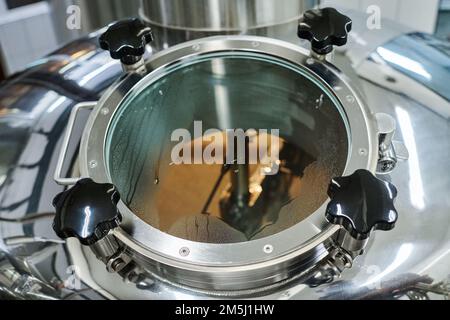 Vista ad angolo alto del contenitore con birra prodotta in officina Foto Stock