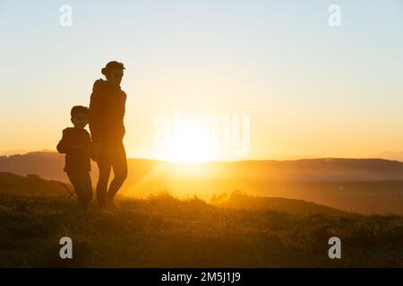 Madre e figlio si sono insilati al tramonto mentre camminavano Foto Stock