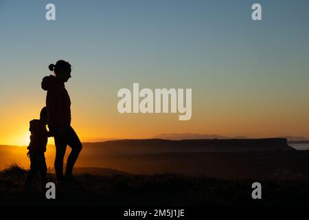 Madre e figlio si sono insilati al tramonto mentre camminavano Foto Stock