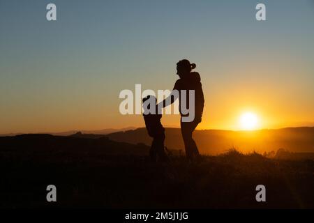 Madre e figlio si sono insilati al tramonto mentre camminavano Foto Stock