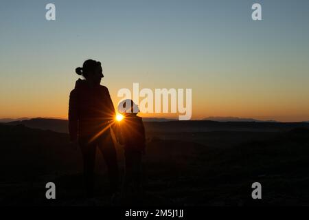 Madre e figlio si sono insilati al tramonto mentre camminavano Foto Stock