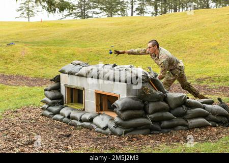 Oregon Army National Guard Soldier lancia una granata di allenamento verso una serie di obiettivi durante la 2022 Best Warrior Competition, marzo 18, a Camp Rilea vicino Warrenton, Orea. Durante il concorso, i soldati più arruolati e gli ufficiali non commissionati sono testati per la loro attitudine attraverso interviste al bordo, prove di idoneità fisica, esami scritti, simulazioni di guerra urbana e altri compiti fondamentali del soldato relativi all'ambiente operativo dell'esercito. (Foto della Guardia Nazionale aerea di John Hughel, Dipartimento militare dell'Oregon) Foto Stock