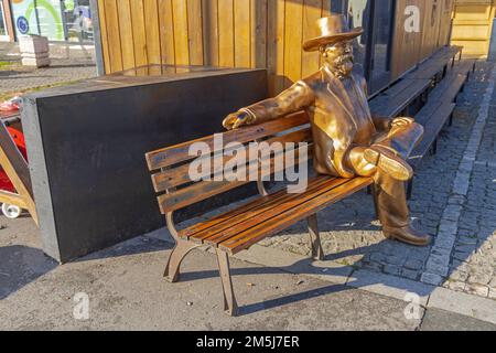 Belgrado, Serbia - 25 dicembre 2022: Posti a sedere Life Size Jack Daniels statue al Bench Tennessee Whiskey Symbol al mercato invernale. Foto Stock