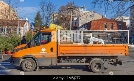 Belgrado, Serbia - 25 dicembre 2022: Veicolo arancione per la raccolta dei rifiuti comunitari nella Capital City Street Winter. Foto Stock