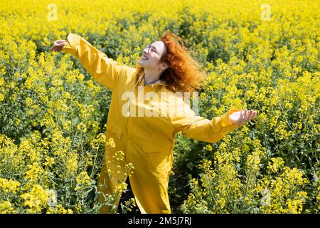 Una donna che gode il calore del sole in una giornata di primavera soleggiata Foto Stock