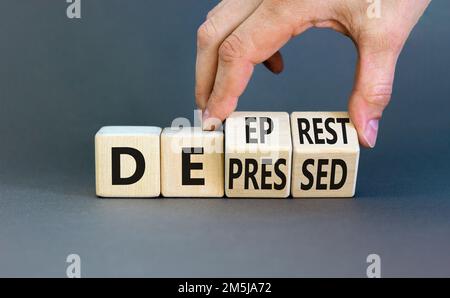 Simbolo premuto o a riposo profondo. Concetto di parola depresso o profondo riposo su cubi di legno. Bellissimo sfondo grigio tavolo. Mano uomo d'affari. Medico AN Foto Stock