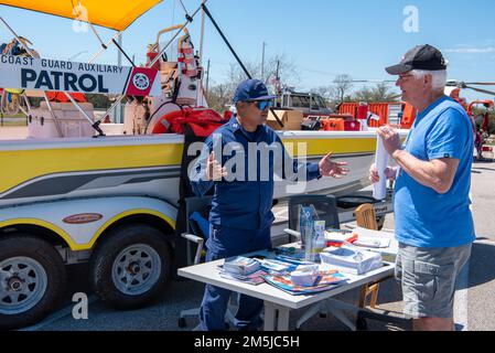 Glenn Colaco, auxiliarista della Guardia Costiera, spiega il ruolo della Guardia Costiera ausiliaria a un membro del pubblico durante la Giornata della comunità di Houston-Galveston a Houston, Texas, 19 marzo 2022. Durante l'evento, i membri della Guardia Costiera del settore Houston-Galveston e delle unità circostanti hanno esposto le attrezzature e discusso varie missioni della Guardia Costiera. Foto Stock