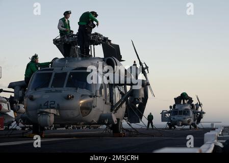 OCEANO ATLANTICO – i marinai eseguono le procedure pre-volo su un elicottero MH-60s Sea Hawk attaccato all'elicottero Sea Combat Squadron (HSC) 28, sul ponte di volo della nave d'assalto anfibia di classe Wasp USS Kearsarge (LHD 3) durante il problema della battaglia della flotta 22-1 marzo 19, 2022. FBP 22-1 integra capacità navali per supportare operazioni speciali, fornire difesa a terra e in mare, e sviluppare l'uso di veicoli subacquei senza equipaggio Foto Stock