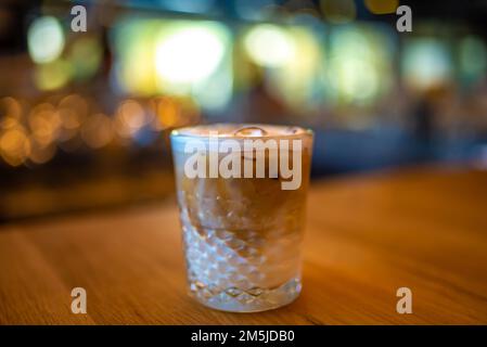 Un caffè latte freddo in vetro di cristallo un tavolo da bar di legno Foto Stock