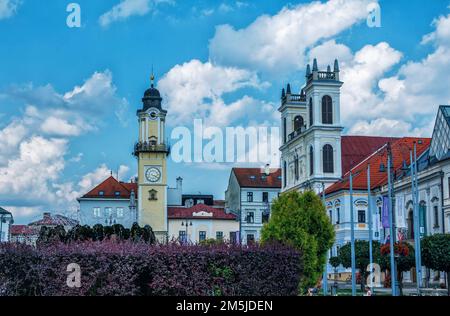 Banska Bystrica, Slovacchia - 15 agosto 2021: Vista di Piazza SNP - edifici storici colorati, torre dell'orologio e persone che camminano intorno. Foto Stock