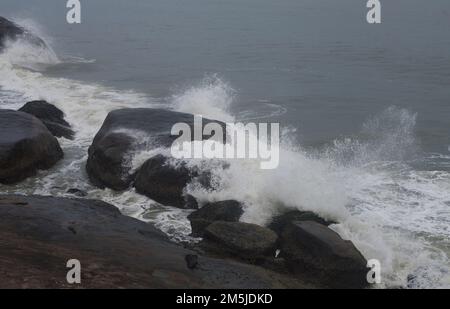 Onde che si schiantano contro le rocce su una costa rocciosa inviando spruzzi nell'aria Foto Stock