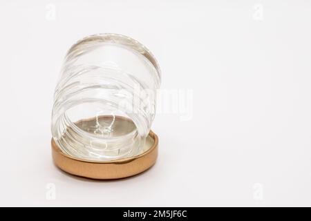 Primo piano di una piccola marmellata vuota e pulita conserva il vaso di vetro con un coperchio metallico a vite color bronzo Foto Stock
