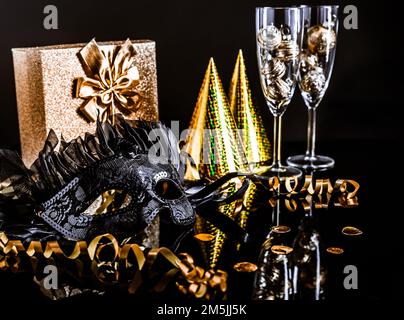 Maschera di Carnevale con presente e festa capanna e nastro su sfondo nero Foto Stock