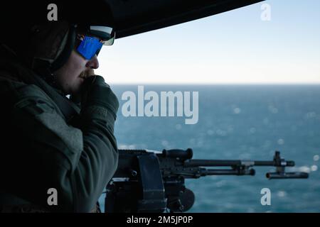 Oceano ATLANTICO - Gunnery Sgt. Earl Maddox, un capo equipaggio di elicotteri con l'unità di spedizione marina 22nd vola in un elicottero UH-1Y Venom, attaccato a Marine Medium Tiltrotor Squadron 263 (rinforzato), durante un esercizio di fuoco vivo con la nave d'assalto anfibio WASP USS Kearsarge (LHD 3) Durante Fleet Battle Problem (FBP) 22-1, 20 marzo 2022. FBP 22-1 integra capacità navali per supportare operazioni speciali, fornire difesa a terra e in mare, e sviluppare l'uso di veicoli subacquei senza equipaggio. Foto Stock