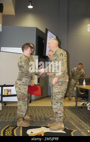 Il comando principale David Hanson, 157th Brigata della fanteria, prima divisione dell'esercito est, si congratula con Sgt. 1st Classe Kelsey Collard per la sua eccezionale prestazione durante l'esercizio post della divisione della fanteria 38th a Fort Campbell, Ky., 20 marzo 2022. L'esercizio ha offerto alla sede centrale della divisione l'opportunità di formare la leadership e il personale utilizzando sistemi di comando della missione all'interno di una simulazione di operazioni di combattimento a terra su larga scala. Foto Stock