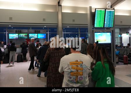 I passeggeri aspettano in fila alla biglietteria Southwest per riprenotare i voli ritardati e cancellati all'aeroporto internazionale di Sacramento, sabato 24 dicembre 2022, a Sacramento. Foto Stock